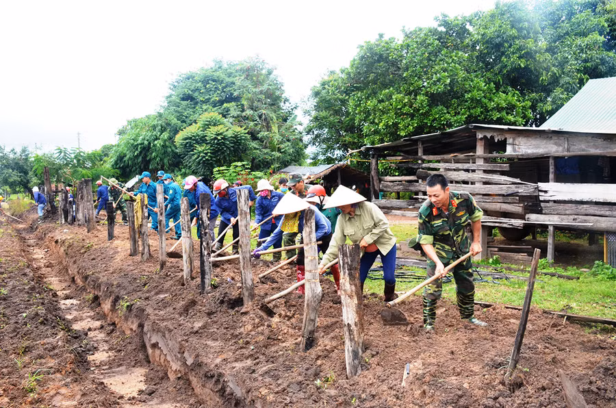 Cán bộ, chiến sĩ Trung đoàn Kinh tế-Quốc phòng 710 giúp người dân xã Ia Lâu (huyện Chư Prông) làm hàng rào. Ảnh: Vĩnh Hoàng