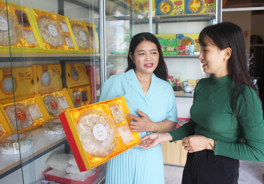 Chị Hà Thị Đông (bìa trái, thôn Bình Hòa, xã Chư Răng, huyện Ia Pa) giới thiệu sản phẩm yến sào Sơn Đông cho khách hàng. Ảnh: Phan Lài