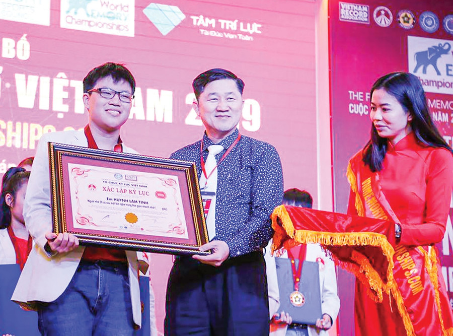 Huỳnh Lâm Tính (trái) nhận Bằng xác lập kỷ lục Siêu trí nhớ từ Tổ chức Kỷ lục VN