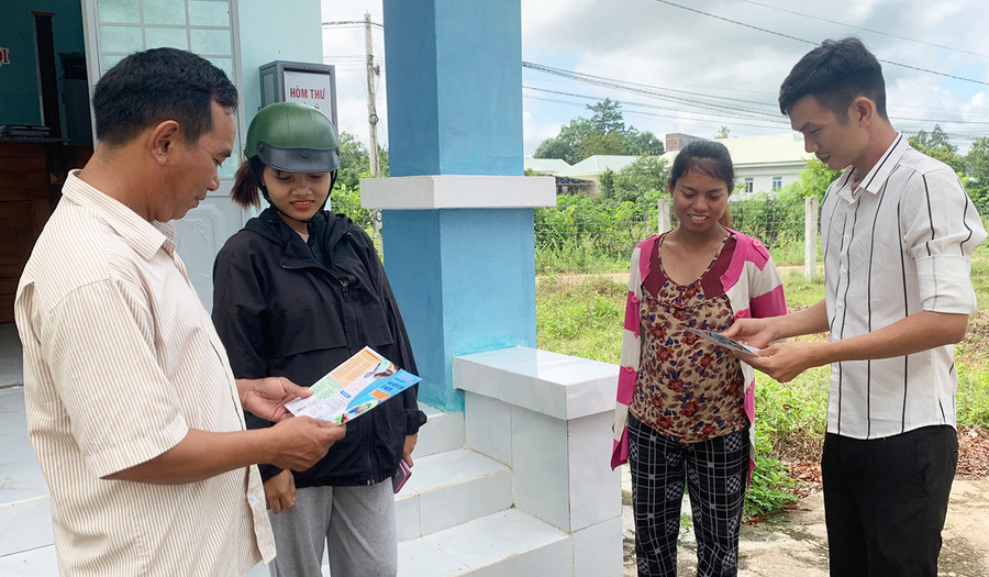  Anh Nguyễn Chí Hữu (bìa phải, Đại lý BHYT xã Ia Sao) tuyên truyền cho người dân về quyền lợi khi tham gia BHYT. Ảnh: Vũ Chi
