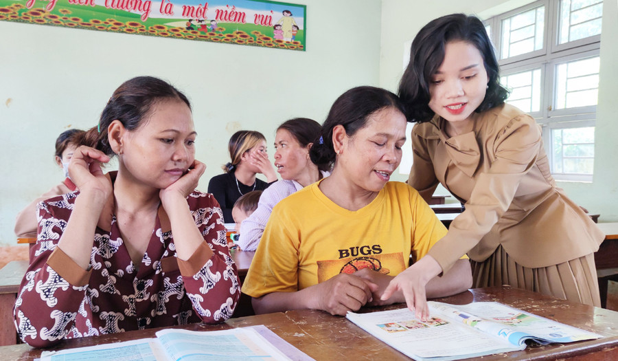  Cô Rơ Lan Vy (bìa phải) trong một buổi dạy ở lớp xóa mù chữ miễn phí cho người dân. Ảnh: Thiên Di