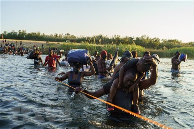 Người di cư từ Ciudad Acuna, bang Coahuila (Mexico) vượt qua khu vực biên giới ở Rio Grande để vào Mỹ, ngày 20/9/2021. Ảnh: AFP/TTXVN