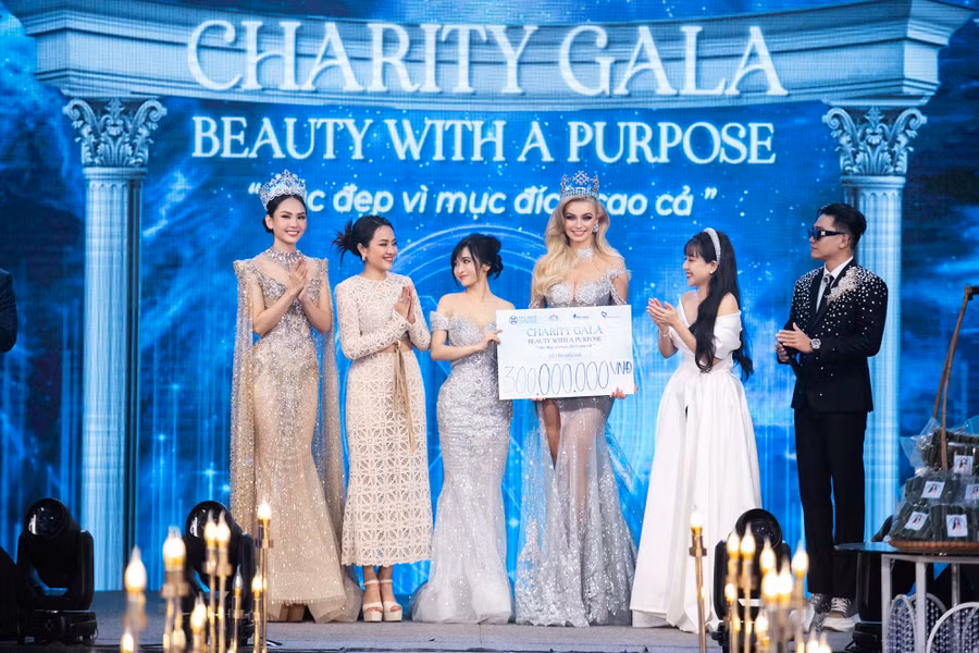  Mina Phạm - bà xã đại gia Minh Nhựa (thứ 3 từ trái sang) là người đại diện lên sân khấu nhận kỷ niệm chương và trao số tiền tượng trưng cho hai hoa hậu. Ảnh: BTC