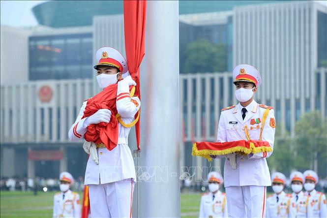 3 chiến sĩ của đội hồng kỳ nghiêm trang bước lên bục để chuẩn bị thực hiện các nghi thức chính. Lúc 5h59, chiến sĩ mang Quốc kỳ treo lên cột cờ.  3 chiến sĩ của đội hồng kỳ nghiêm trang bước lên bục để chuẩn bị thực hiện các nghi thức chính. Lúc 5h59, chiến sĩ mang Quốc kỳ treo lên cột cờ.