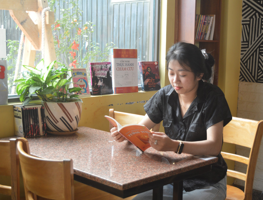 Tranh thủ lúc cửa hàng vắng khách, bạn Nguyễn Thị Thanh Thảo-nhân viên pha chế-tìm đọc những cuốn sách liên quan đến nghề pha chế. Ảnh: Phương Dung