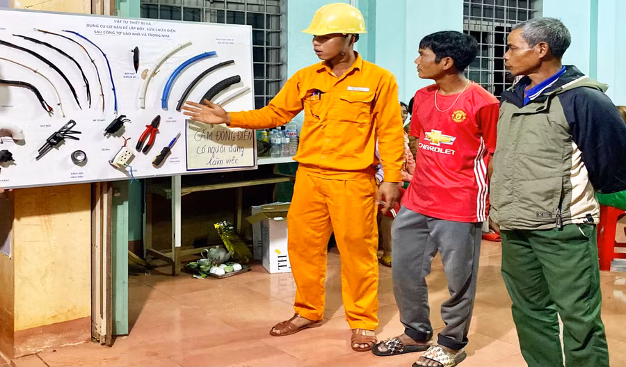 Công nhân Điện lực Mang Yang hướng dẫn người dân sử dụng điện an toàn. Ảnh: Kim Linh