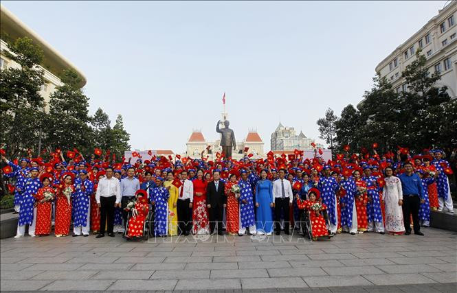 Lãnh đạo TP. Hồ Chí Minh chụp ảnh lưu niệm cùng 100 cặp đôi tham dự Lễ cưới tập thể dưới tường đài Bá Hồ. Ảnh nguồn báo Tuổi trẻ