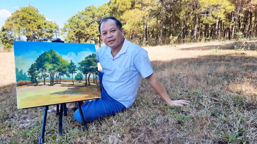 Hoạ sĩ Nguyễn Văn Điền bên tác phẩm “Đồi cỏ hồng”. Ảnh: Lê Hùng