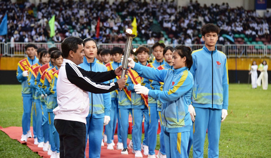 Bí thư Tỉnh uỷ Hồ Văn Niên tiếp nhận ngọn đuốc từ đoàn rước đuốc tại lễ khai mạc. Ảnh: Đức Thuỵ