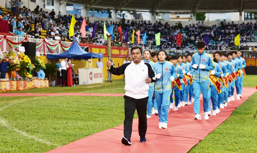 Ủy viên Ban Chấp hành Trung ương Đảng, Bí thư Tỉnh ủy, Chủ tịch HĐND tỉnh Hồ Văn Niên nhận ngọn đuốc từ các vận động viên để thắp sáng đài lửa Đại hội. Ảnh: Đức Thụy