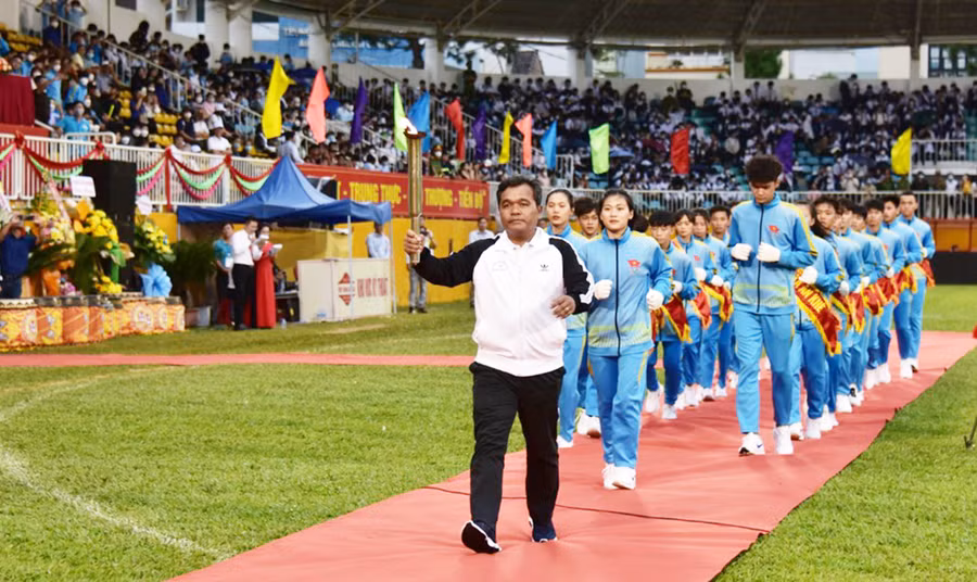 Ủy viên Ban Chấp hành Trung ương Đảng, Bí thư Tỉnh ủy, Chủ tịch HĐND tỉnh Hồ Văn Niên nhận ngọn đuốc từ các vận động viên để thắp sáng đài lửa Đại hội. Ảnh: Đức Thụy