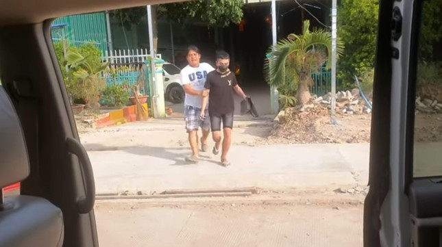 Hiệp sĩ Nguyễn Thanh Hải (trái) đưa các nạn nhân ra xe sau khi trao tiền chuộc cho những người đang quản thúc các lao động Việt Nam