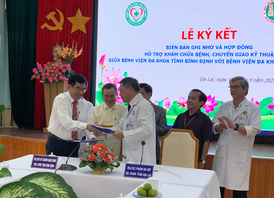 Bác sĩ CKII Võ Thành Nam Bình (hàng trên, bên trái)- Phó Giám đốc Bệnh viện Đa khoa tỉnh Bình Định, bác sĩ CKII Phạm Bá Mỹ (hàng trên, bên phải)- Giám đốc Bệnh viện Đa khoa tỉnh đại diện hai đơn vị ký kết biên bản ghi nhớ và hợp đồng. Ảnh Như Nguyện