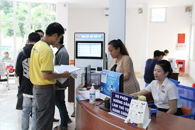 Cán bộ Trung tâm Hành chính công Đắk Lắk hướng dẫn người dân làm thủ tục. Ảnh: T.X 