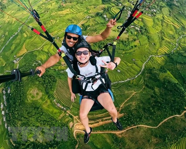 Du khách bay đôi cùng phi công để trải nghiệm ngắm cảnh đẹp ruộng bậc thang mùa lúa chín ở Mù Cang Chải, Yên Bái. Ảnh: TTXVN phát