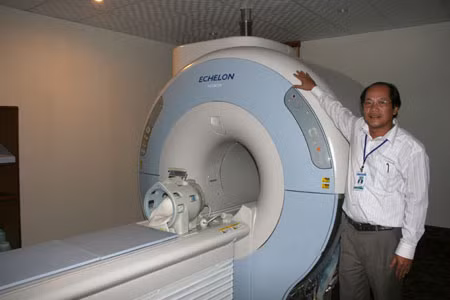 Bác sĩ Trần Hợp bên cạnh máy MRI. 