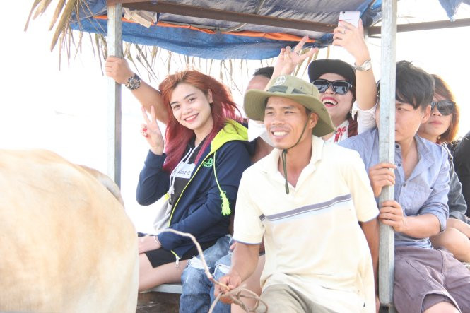 Du khách thích thú ngồi trên chiếc xe bò vừa gần gũi vừa mới lạ.