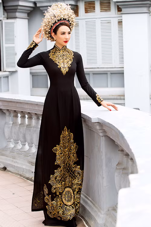 Với chiếc áo kiểu truyền thống, nhà thiết kế sử dụng hoa văn cung đình trên nền đen tạo nên sự quyền uy. Chiếc mấn được trang trí bởi ngọc trai, dây đồng.