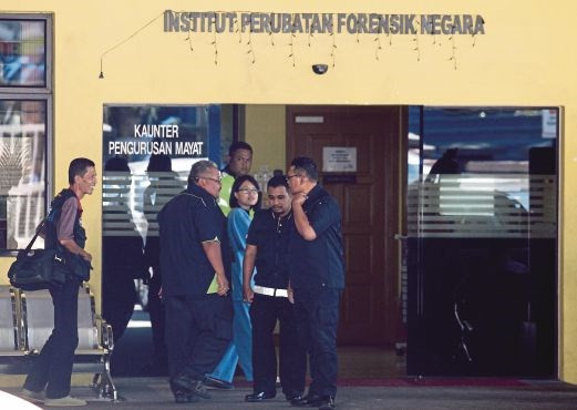 Cảnh sát và phóng viên báo chí đứng trước một bệnh viện ở Kuala Lumpur, nơi người ta đang khám nghiệm pháp y thi thể ông Jong-nam.