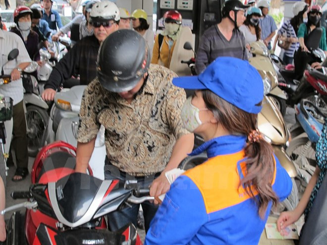 Nhân viên Petrolimex đang bán xăng cho khách hàng. Nhân viên Petrolimex đang bán xăng cho khách hàng.