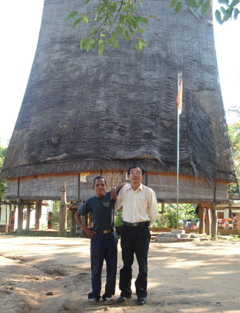 A Phẻo (bên trái) và tác giả trước sân nhà rông. 