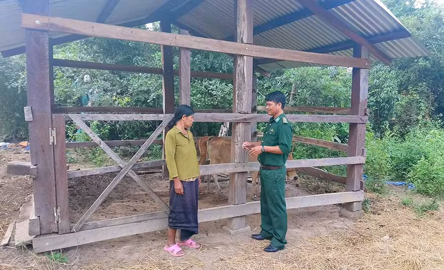  Thượng úy Rơ Ô Thuy trò chuyện với bà Rơ Mah Krét (làng Krông). Ảnh: T.K.N