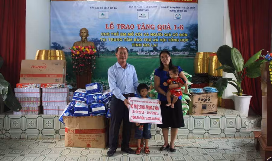 Đại diện Công ty cổ phần Quản lý và sửa chữa đường bộ Gia Lai tặng quà cho 2 em thiếu nhi có hoàn cảnh đặc biệt. Ảnh: Phan Lài