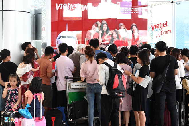  Hành khách xếp hàng tại quầy vé để yêu cầu hãng bồi thường sau khi hàng loạt chuyến bay bị chậm, hủy. Ảnh: Hoàng Hà.