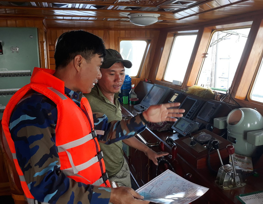  Thiếu tá Trần Cộng Hòa-Phó Chỉ huy trưởng Trung tâm HC-KT thị trấn Trường Sa (bìa trái) hướng dẫn ngư trường đánh bắt cho ngư dân. Ảnh: C.H