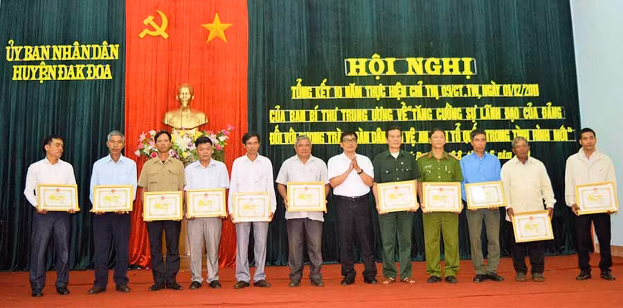  Chủ tịch UBND huyện Đak Đoa Phạm Minh Trung tặng giấy khen cho các tập thể, cá nhân có thành tích xuất sắc trong xây dựng Tổ tự quản về an ninh trật tự. Ảnh: Đ.Y