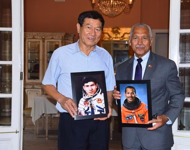  Thiếu tướng Charles Frank Bolden Jr. và nhà du hành vũ trụ Việt Nam, Trung tướng Phạm Tuân chụp ảnh cùng ảnh chân dung của họ khi là nhà du hành vũ trụ. (Ảnh: Đại sứ quán Mỹ tại Việt Nam)