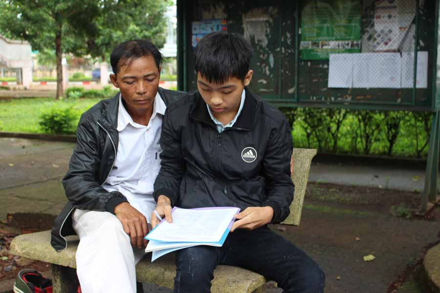 Trong những ngày thi, em Bùi Văn Cường (bìa phải) luôn có sự đồng hành của bố. Ảnh: T.B