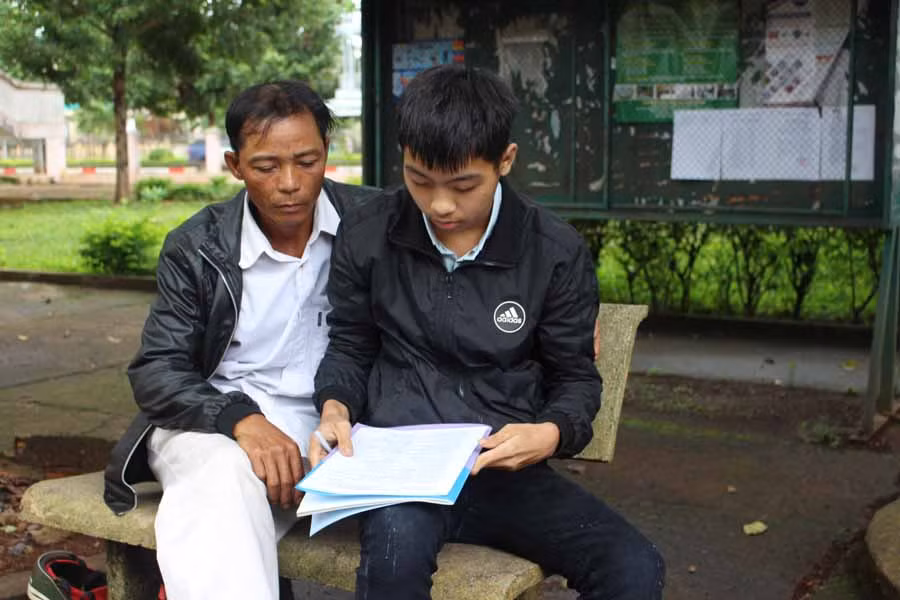 Trong những ngày thi, em Bùi Văn Cường (bìa phải) luôn có sự đồng hành của bố. Ảnh: T.B