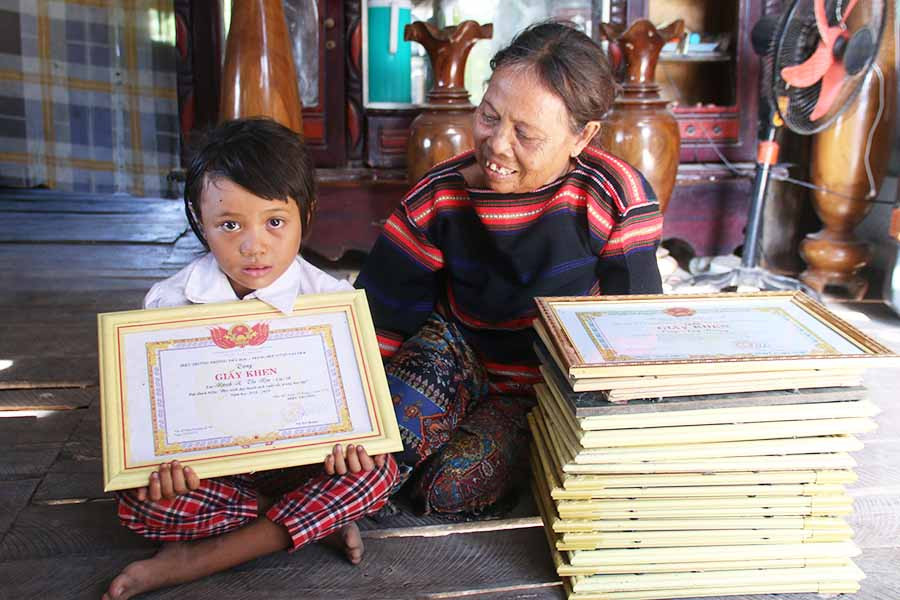 Bà Rmah H'Đoan khoe giấy khen và thành tích học tập của con cháu. Ảnh: P.N Bà Rmah H'Đoan khoe giấy khen và thành tích học tập của con cháu. Ảnh: P.N