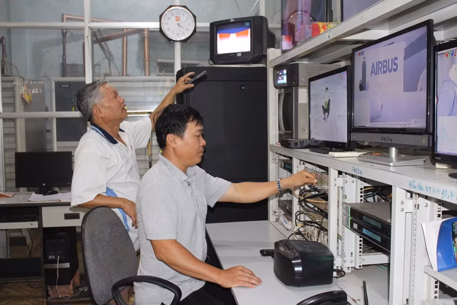  Từ trái sang: Ông Nguyễn Hồng Tòng và anh Nguyễn Văn Thành đang kiểm tra tín hiệu đường truyền. Ảnh: T.B