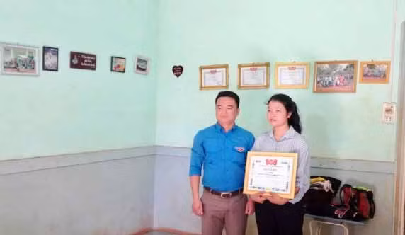 Phó Bí thư Tỉnh đoàn Đỗ Duy Nam tặng bằng khen cho em Bĩch. Ảnh: Phan Lài