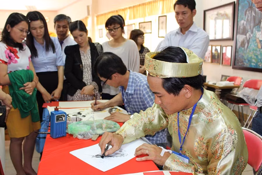 Các thành viên viết chữ thư pháp tặng người hâm mộ. Ảnh: Phan Lài