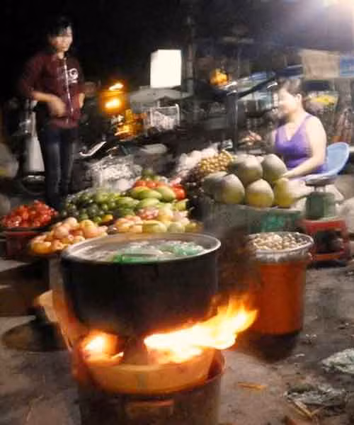  Ngọn lửa đỏ rực bập bùng dưới nồi trứng lộn, một ít hoa quả tươi bày ngay ngắn trên kệ gỗ…là những món hàng đêm tại đây. Ảnh: Trần Dung