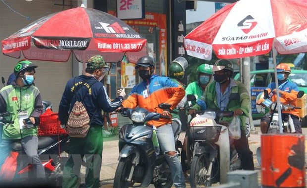 Rất đông những người giao hàng (shipper) tại giao lộ đường Phạm Văn Đồng-Phan Văn Trị (quận Gò Vấp). Ảnh: Thanh Vũ/TTXVN