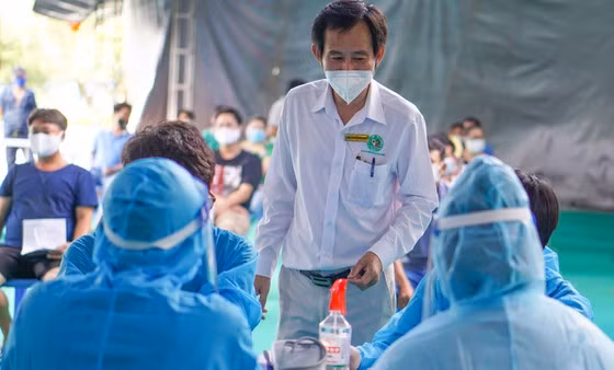 BS-CKII Trần Văn Khanh động viên tinh thần các tình nguyện viên trong đội hình tiêm ngừa lưu động tại cụm công nghiệp Phong Phú, phường Tăng Nhơn Phú B, TP Thủ Đức. Ảnh: Hoàng Hùng