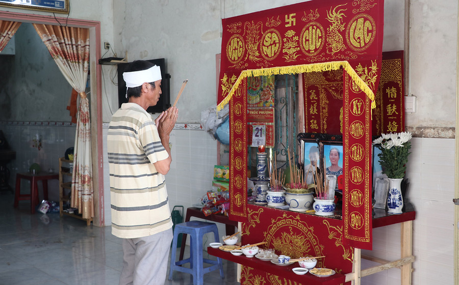 Ông Ngô Văn Quang (thôn 9, xã Yang Trung, huyện Kông Chro) nghẹn ngào trước di ảnh của vợ và 2 con. Ảnh: An Phát