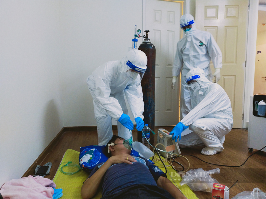 Các y, bác sĩ đang đặt oxy cho một bệnh nhân F0 đang khó thở tại Bệnh viện dã chiến số 7. Ảnh: Chinh Hoàng.