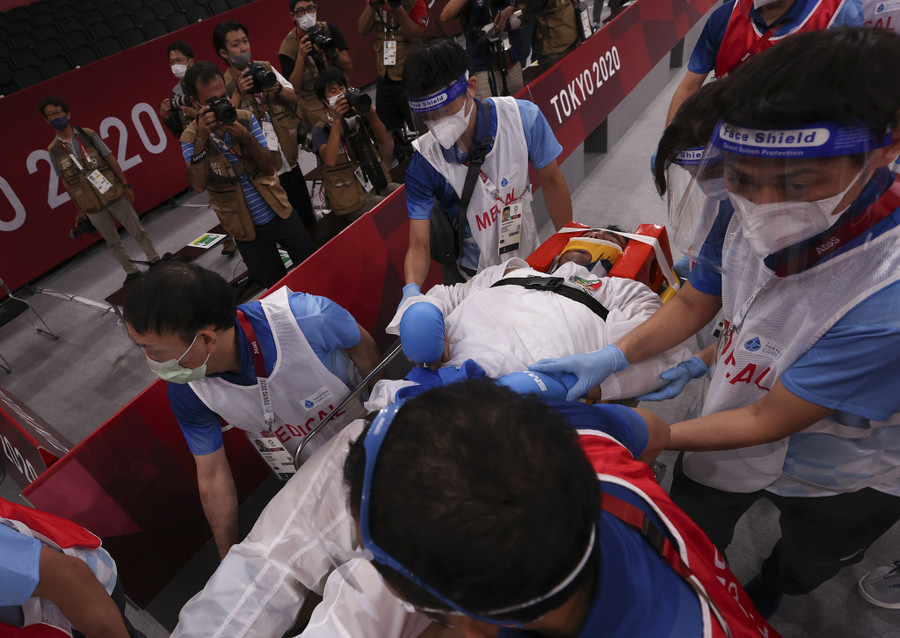 VĐV Iran được cấp cứu bằng cáng khỏi sân thi đấu. Ảnh: Reuters