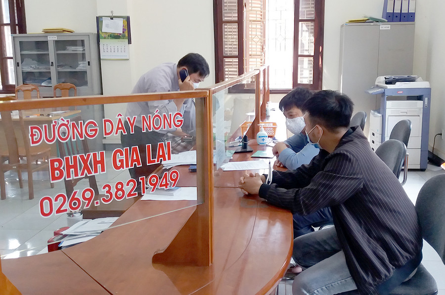 Nhân viên BHXH tỉnh hướng dẫn người dân các thủ tục liên quan chính sách BHXH. Ảnh: Như Nguyện