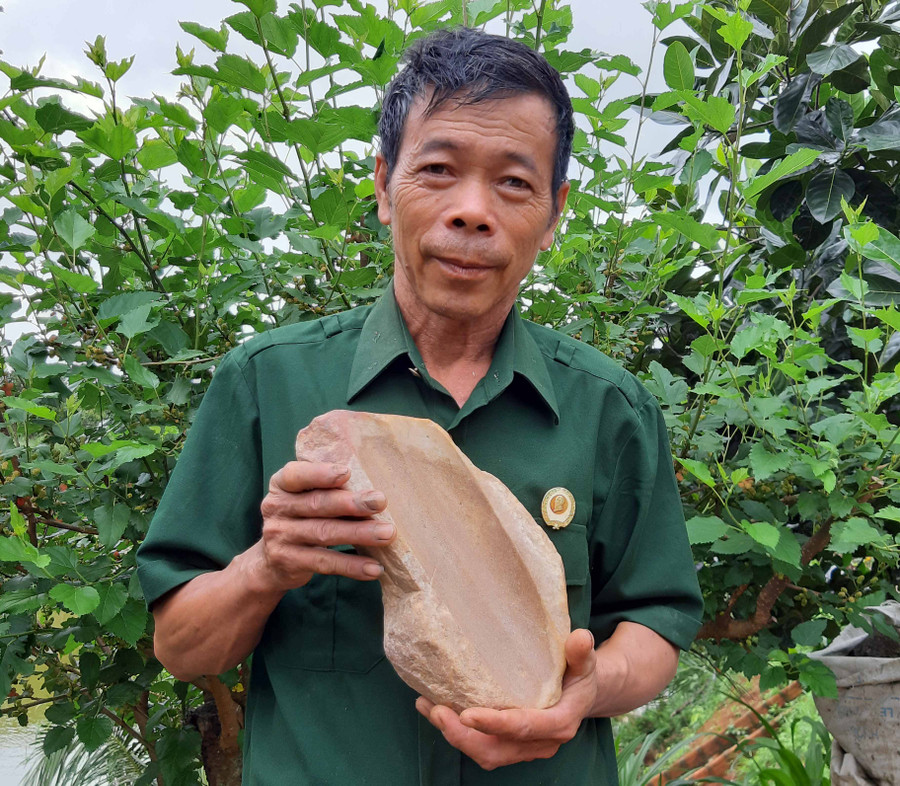 Ông Đặng Thanh Vân và bàn mài đá có niên đại cách nay 4.000-3.500 năm. Ảnh: Nguyễn Quang Tuệ Ông Đặng Thanh Vân và bàn mài đá có niên đại cách nay 4.000-3.500 năm. Ảnh: Nguyễn Quang Tuệ