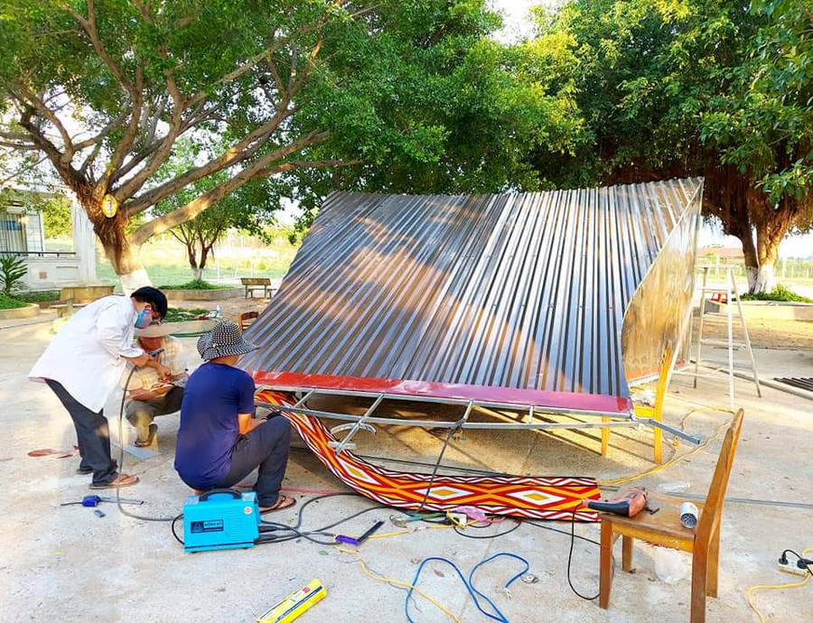 Các thầy giáo đang hàn mái tôn cho nhà rông (ảnh trước tháng 4-2021). Ảnh: Nguyễn Tú