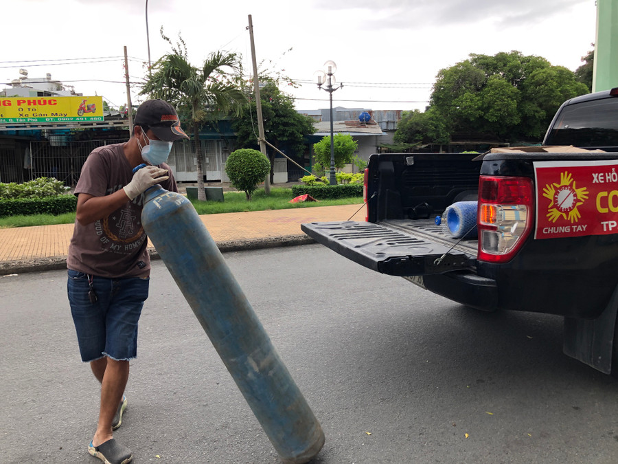 Anh Long mang ô xy đến bệnh viện dã chiến cho F0. Ảnh: Phạm Hữu