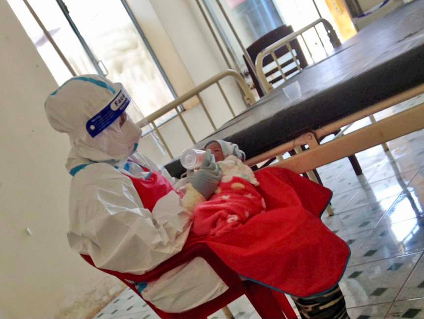 Bé trai được nhân viên y tế chăm sóc. Ảnh: Như Nguyện 