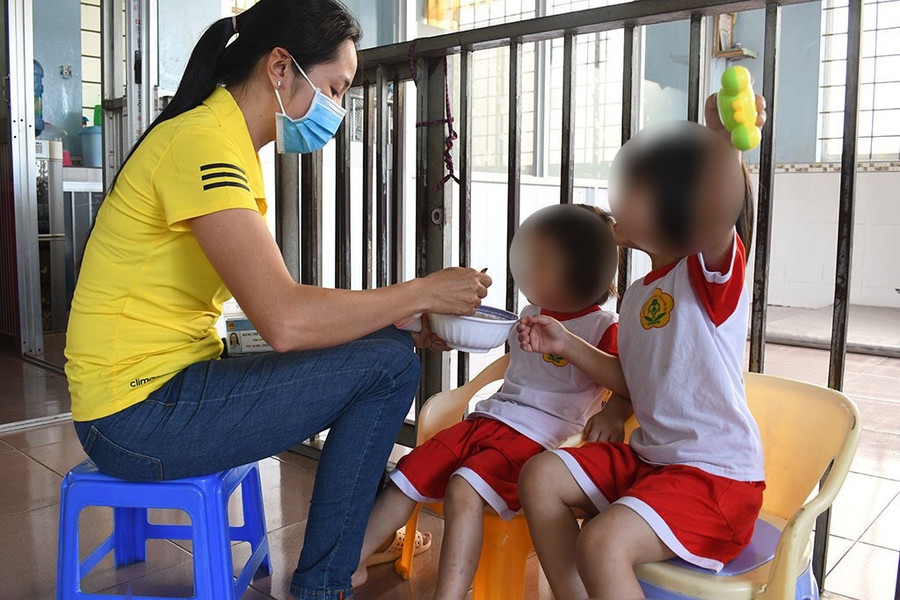 Chị Đặng Thị Mỹ Linh đang cho trẻ ăn. Ảnh: Quốc Lê