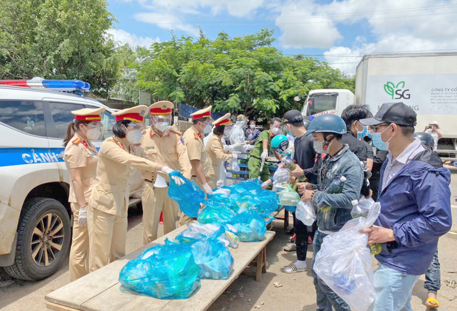 Lực lượng Cảnh sát Giao thông Công an tỉnh hỗ trợ lương thực cho người dân về từ các tỉnh phía Nam tại chốt kiểm soát phòng-chống dịch Covid-19 khu vực cầu 110 (huyện Chư Pưh). Ảnh: Lê Anh